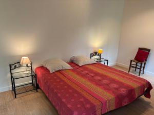 a bedroom with a large bed with two chairs at La Petite Ferme des Etoiles in Mauroux