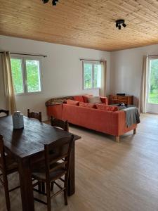 a living room with a red couch and a table at La Petite Ferme des Etoiles in Mauroux