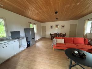 a living room with a red couch and a table at La Petite Ferme des Etoiles in Mauroux