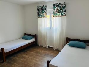 two beds in a room with a window at Djekljak House in Virpazar +10 photos