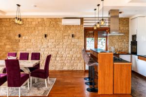 a kitchen and dining room with a table and chairs at Villa Vitanika in Kunjići