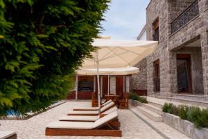 a patio with a table and an umbrella at Villa Vitanika in Kunjići