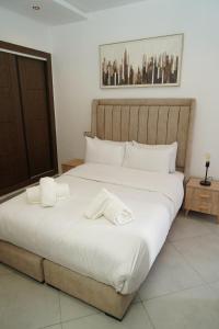 a bedroom with a large bed with two towels on it at Chic Moderne avec Touche Marocaine in Kenitra