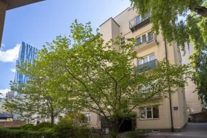 a building with a tree in front of it at Sienna Central Studio & Parking in Warsaw