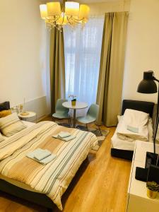 a bedroom with a large bed and a table and chairs at In My Style Apartman in Budapest