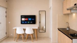a kitchen with a white table and two white chairs at Milestone Villa in Antananarivo