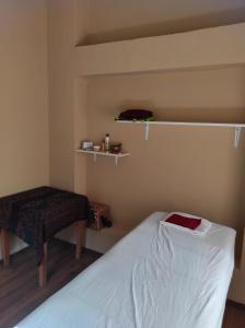 a small bedroom with a bed and a stool at Casa Unupaccha in Calca