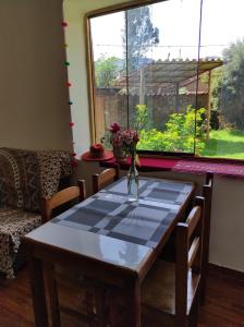 a dining room table with a vase of flowers on it at Casa Unupaccha in Calca
