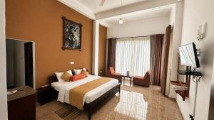 a hotel room with a bed and a desk and a television at Thuruliya Hotel in Ramboda