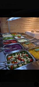 a buffet with many trays of different types of food at Cabañas Portofino todo incluido in Ramallo