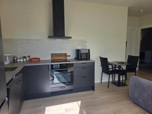 a kitchen with a stove top oven next to a table at Fjordstay in Vennesla