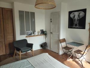 a bedroom with a bed and a chair and an elephant on the wall at La Canardière in Pendé