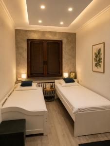 two beds in a room with two windows at NDK - Dream House in Sofia +6 photos