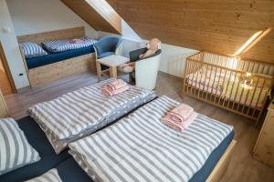 a room with two beds and a chair and a crib at Chalupa Rébus in Loučná nad Desnou