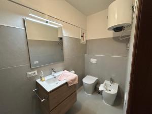 a bathroom with a sink and a toilet and a mirror at Residence Solarium Qua in Bibione +14 photos