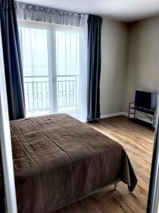 a bedroom with a bed and a large window at DL Apartments in Aheloy