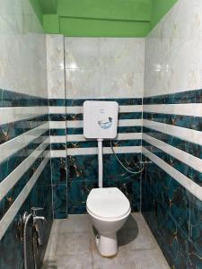 a bathroom with a toilet with blue and white stripes at Snehalata Lodge in Badarpur