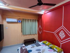 a room with a bed and a ceiling fan at Snehalata Lodge in Badarpur