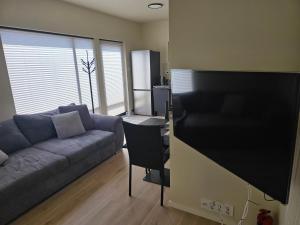 a living room with a couch and a desk at Fjordstay in Vennesla +8 photos