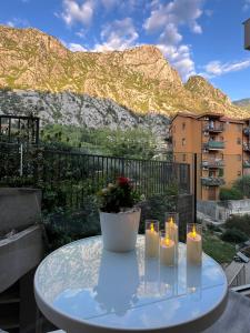 a table with candles and a vase with flowers on it at Luxury Apartment Milos in Dobrota