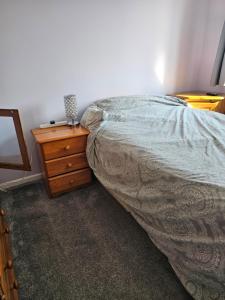 a bedroom with a bed and a wooden dresser at Quiet Room with ensuite in Chippenham