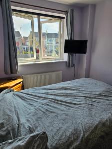a bedroom with a bed and a window at Quiet Room with ensuite in Chippenham