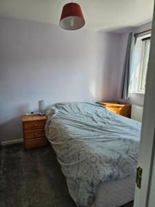 a bedroom with a bed and a dresser and a window at Quiet Room with ensuite in Chippenham