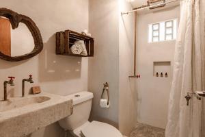 a bathroom with a toilet and a sink and a shower at Ahava Hotel in Playa del Carmen