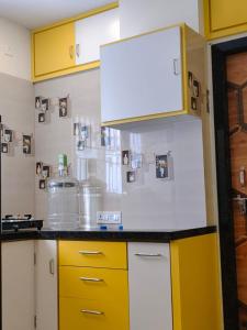 a kitchen with yellow cabinets and a counter top at Kautilya Grand 2 in Kākināda