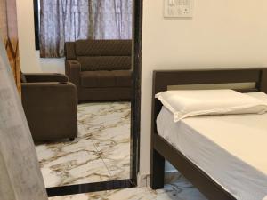 a mirror in a room with a bed and a couch at Kautilya Grand 2 in Kākināda