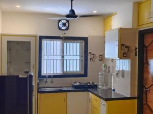 a kitchen with yellow cabinets and a clock on the wall at Kautilya Grand 2 in Kākināda +44 photos