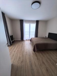a bedroom with a bed and a large window at DL Apartments in Aheloy