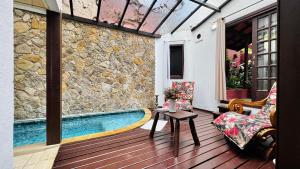 a patio with a swimming pool next to a stone wall at Estalagem Wiesbaden in Monte Verde