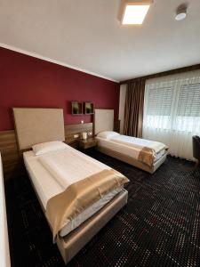 two beds in a hotel room with red walls at Zenith Hotel Frankfurt Airport in Kelsterbach +24 photos