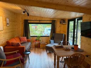 a living room with a couch and a table at Lake District Woodland Cabin - Close to Ambleside & Langdale Valley in Ambleside