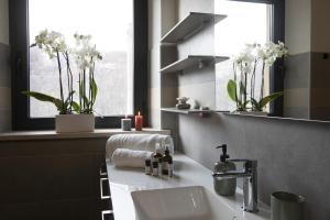 a bathroom with a sink and a window with flowers at Casolare Brindavan Dimora Artemisia in Vaccareccia