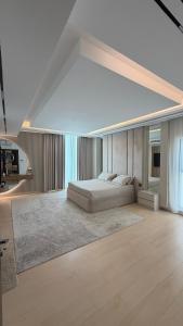 a white bedroom with a bed and a living room at Villa 22 in Ajman 