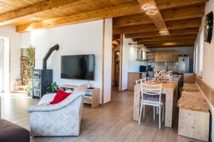 a kitchen and living room with a table and a television at Chalupa Rébus in Loučná nad Desnou