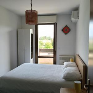 a bedroom with a white bed and a window at Appartamento Velocipede in Cervignano del Friuli