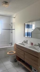 a bathroom with a toilet and a sink and a tub at Les Charmilles in Aytré