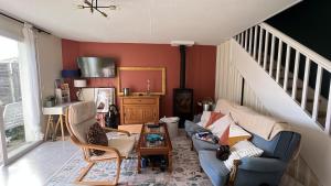 a living room with a blue couch and a staircase at Les Charmilles in Aytré