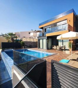 a swimming pool in front of a house at Villa Elmas in Kalkan