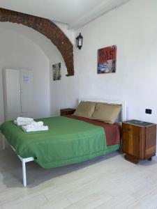 a bedroom with a green bed and a table at Home Ringo in Belvedere Marittimo