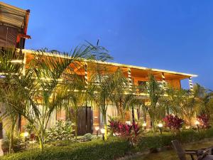 a house with palm trees in front of it at Earavat Resort in Rāmnagar
