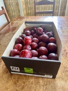 a box of red apples sitting on a table at Pink-Shell in Santiago de Riba-Ul