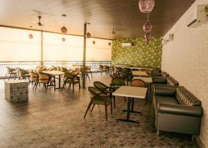 a restaurant with tables and chairs in a room at Hotel Chhaya in Rishīkesh
