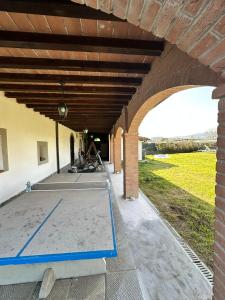 an outdoor patio with a concrete floor and a brick building at B&B Pizziconi Relax in Podere Modello