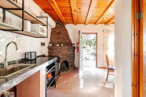 a kitchen with a stone fireplace and a sink at Complejo Ermitazh in Valle Grande