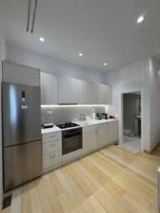 a kitchen with stainless steel appliances and wooden floors at Small home Pyrgos in Panormos