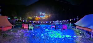 a group of chairs in a garden at night at Kasol Shalom Camps & Cafe in Kasol